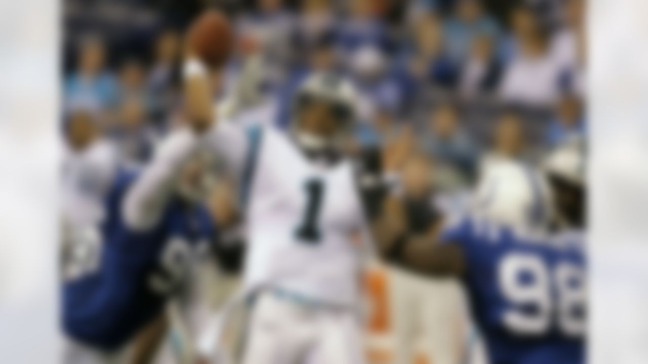 Carolina Panthers quarterback Cam Newton, center, throws under pressure for Indianapolis Colts defensive end Robert Mathis, right, and defensive end Tyler Brayton during the second quarter of an NFL football game in Indianapolis, Sunday, Nov. 27, 2011. (AP Photo/Darron Cummings)