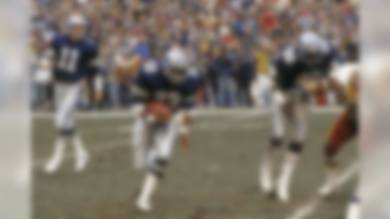 Dallas Cowboys quarterback Danny White (11) looks on while Cowboys running back Tony Dorsett (33) runs the ball behind a lead block by Cowboys fullback Ron Springs (20) during the NFL football game between the Dallas Cowboys and the New York Giants in East Rutherford, New Jersey on October 30, 1983. The Cowboys won the game 38-20 (AP Photo/Paul Spinelli)