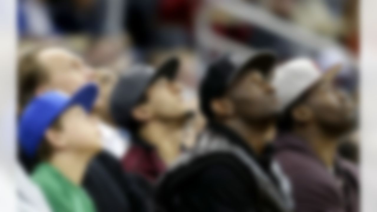 San Francisco 49ers quarterback Colin Kaepernick, center, looks up a jumbotron during an NBA basketball game between the Atlanta Hawks and the Milwaukee Bucks, Wednesday, March 20, 2013, in Atlanta. (AP Photo/David Goldman)