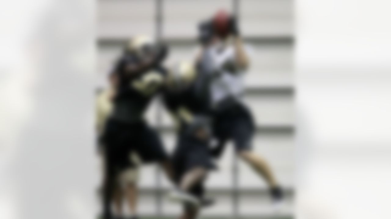 New Orleans Saints wide receiver Andy Tanner (14) pulls in a pass over safety Jerico Nelson (37) and cornerback Cord Parks (31) during NFL football training camp in Metairie, La., Thursday, July 26, 2012. (AP Photo/Gerald Herbert)
