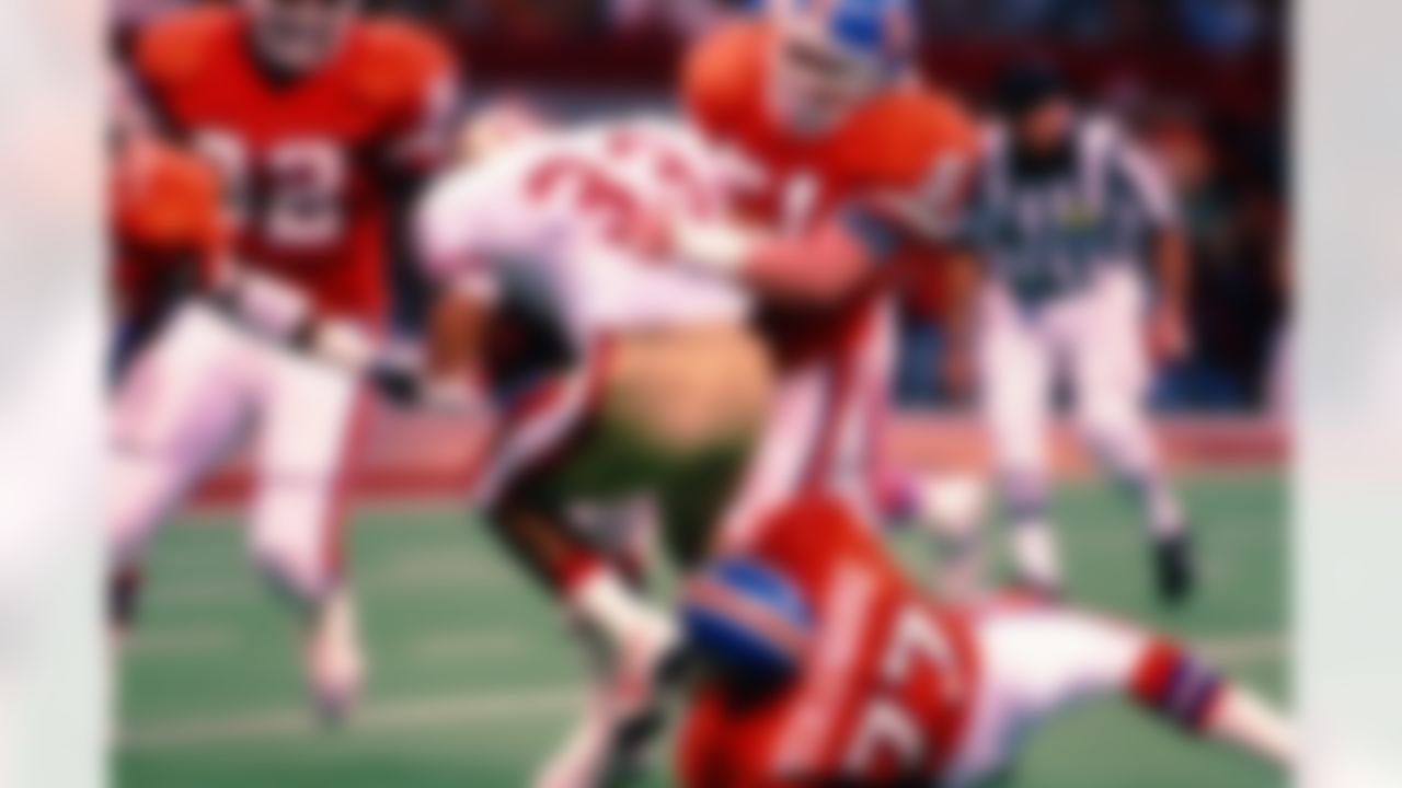 Denver Broncos linebackers Marc Munford (51) and Karl Mecklenburg (77) team up to stop San Francisco 49ers running back Roger Craig (33) during a Super Bowl XXIV NFL game against the San Francisco 49ers in New Orleans, on January 28, 1990. The 49ers defeated the Broncos 55-10. (National Football League)