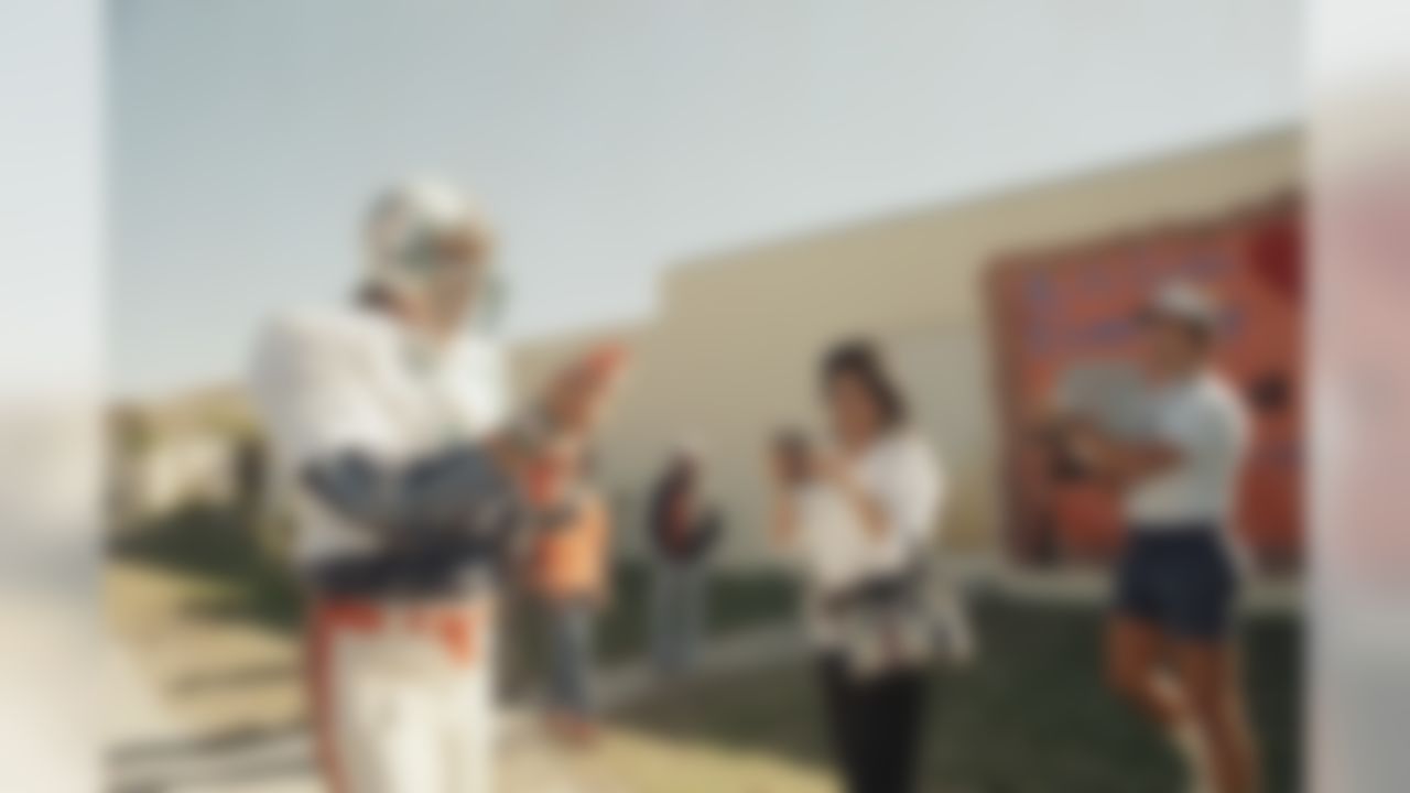 Miami Dolphins quarterback Dan Marino heads toward the practice field in Miami, Fla., bypassing camera-toting admirers and a poster wishing the team good luck in the Super Bowl, made by local elementary school children, Jan. 9, 1985. The team will work but daily in Miami until next Monday when they depart for Oakland, California, where they will practice for the January 20 Super Bowl game against the San Francisco 49ers. (AP Photo/Kathy Willens)