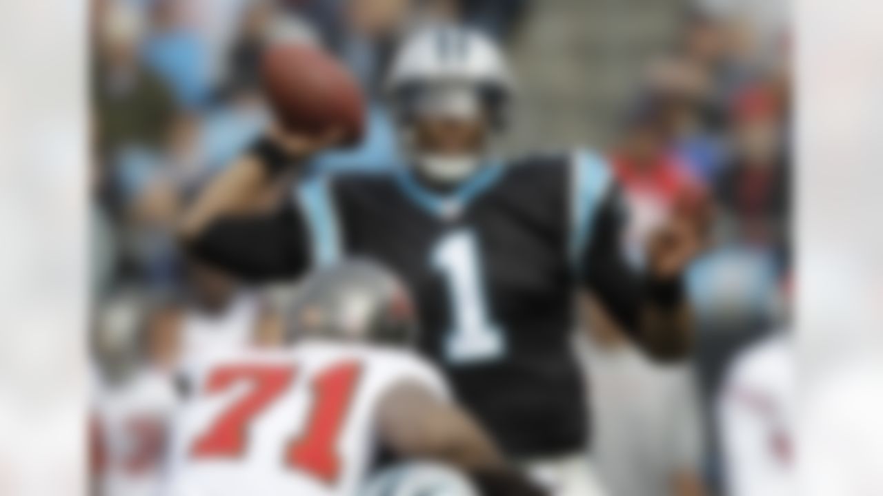 Carolina Panthers' Cam Newton (1) throws a pass as Tampa Bay Buccaneers' Michael Bennett (71) defends during the first quarter of an NFL football game in Charlotte, N.C., Saturday, Dec. 24, 2011. Newton set a rookie passing record on the play. (AP Photo/Chuck Burton)