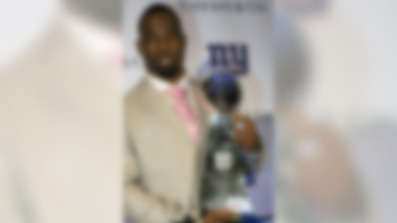 New York Giants defensive end Justin Tuck poses for pictures with the Super Bowl XLVI trophy and ring during a ceremony at Tiffany&Co., Wednesday, May 16, 2012, in New York. The Giants defeated the New England Patriots 21-17 in NFL football's Super Bowl XLVI to attain their fourth championship in franchise history. (AP Photo/John Minchillo)