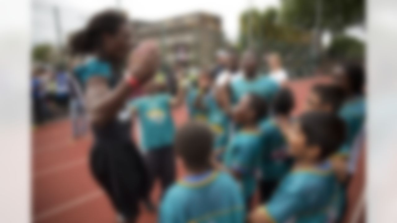 Jacksonville Jaguars safety Sergio Brown cheers with youngsters he was coaching during a NFL Summer Bowl tournament for kids from six London schools that have taken part in a football and education programme, at the Black Prince Community Hub in south London, Wednesday, July 15, 2015. The NFL will stage three international series regular-season games in autumn 2015 at Wembley Stadium in London. (AP Photo/Matt Dunham)