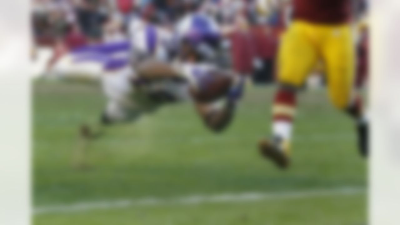 Minnesota Vikings wide receiver Percy Harvin (12) dives into the end zone for a touchdown during the second half of an NFL football game against Washington Redskins in Landover, Md., Saturday, Dec. 24, 2011. (AP Photo/Evan Vucci)