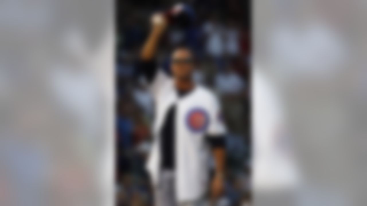 Former Chicago Bears quarterback Jim McMahon waves to crowd before throwing the ceremonial first pitch before a Chicago Cubs and Philadelphia Phillies MLB baseball game on Thursday, Aug. 28, 2008, in Chicago. (AP Photo/Nam Y. Huh)