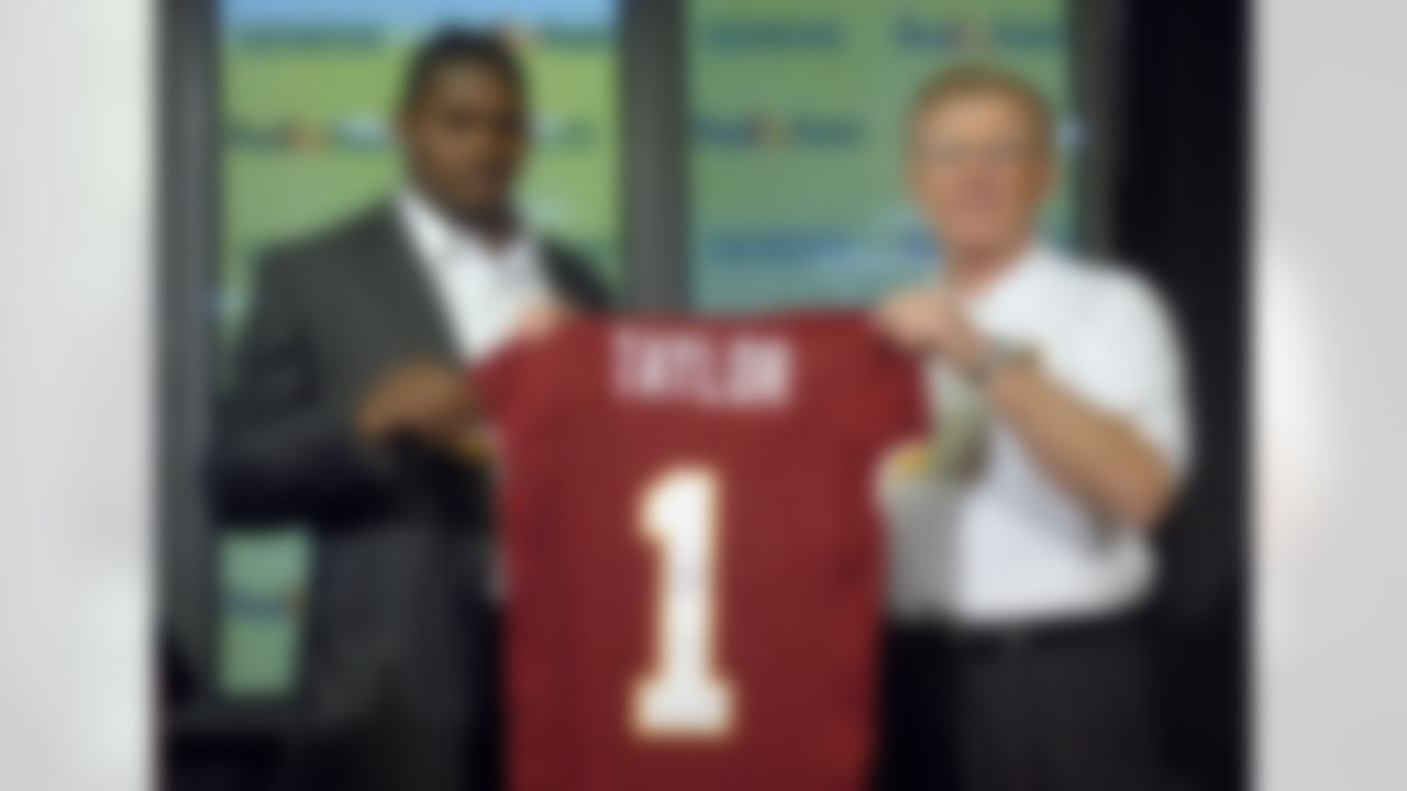 Washington Redskins first-round draft pick Sean Taylor of Miami, left, holds up a Redskins jersey with coach Joe Gibbs during a news conference on Monday April 26, 2004 in Ashburn, Va. (AP Photo/Kevin Wolf)