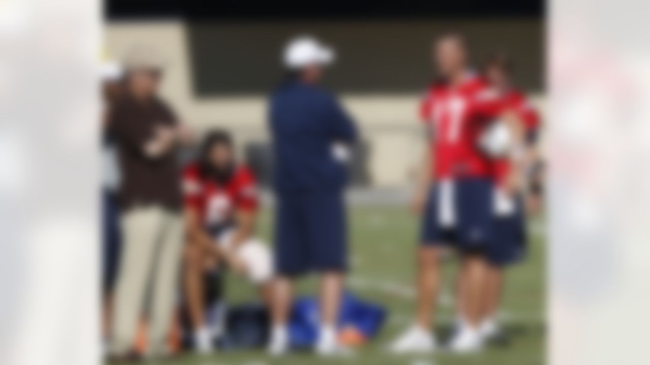 San Diego Chargers quarterback Philip Rivers, right, talks with coach Norv Turner, center, as backup quarterback Charlie Whitehurst sits with his knee in a ice pack after injuring himself on the first day of full squad practice at NFL football training camp, Thursday, July 26, 2012, in San Diego. (AP Photo/Lenny Ignelzi)