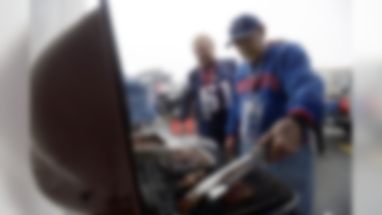 John Skaibinski, right, tends the grill while tailgating with his son Jay in the parking lot of Gillette Stadium before the AFC championship NFL football game between the New England Patriots and the Pittsburgh Steelers, Sunday, Jan. 22, 2017, in Foxborough, Mass. (AP Photo/Elise Amendola)