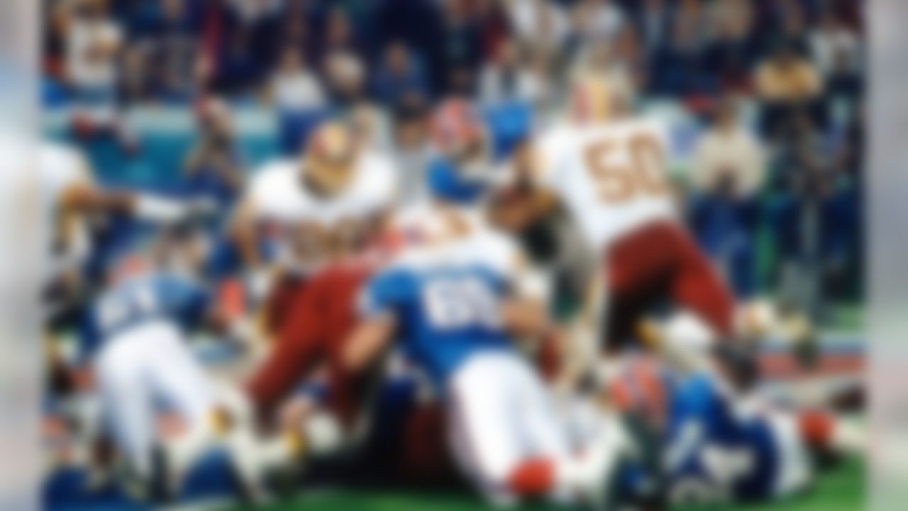 Buffalo Bills Hall of Fame running back Thurman Thomas (34) is met by Washington Redskins linebacker Ravin Caldwell (50) and defensive end James Geathers (97) as he dives for the end zone during Super Bowl XXVI game in Minneapolis, on January 26, 1992. (AP Photo/Vernon Biever)
