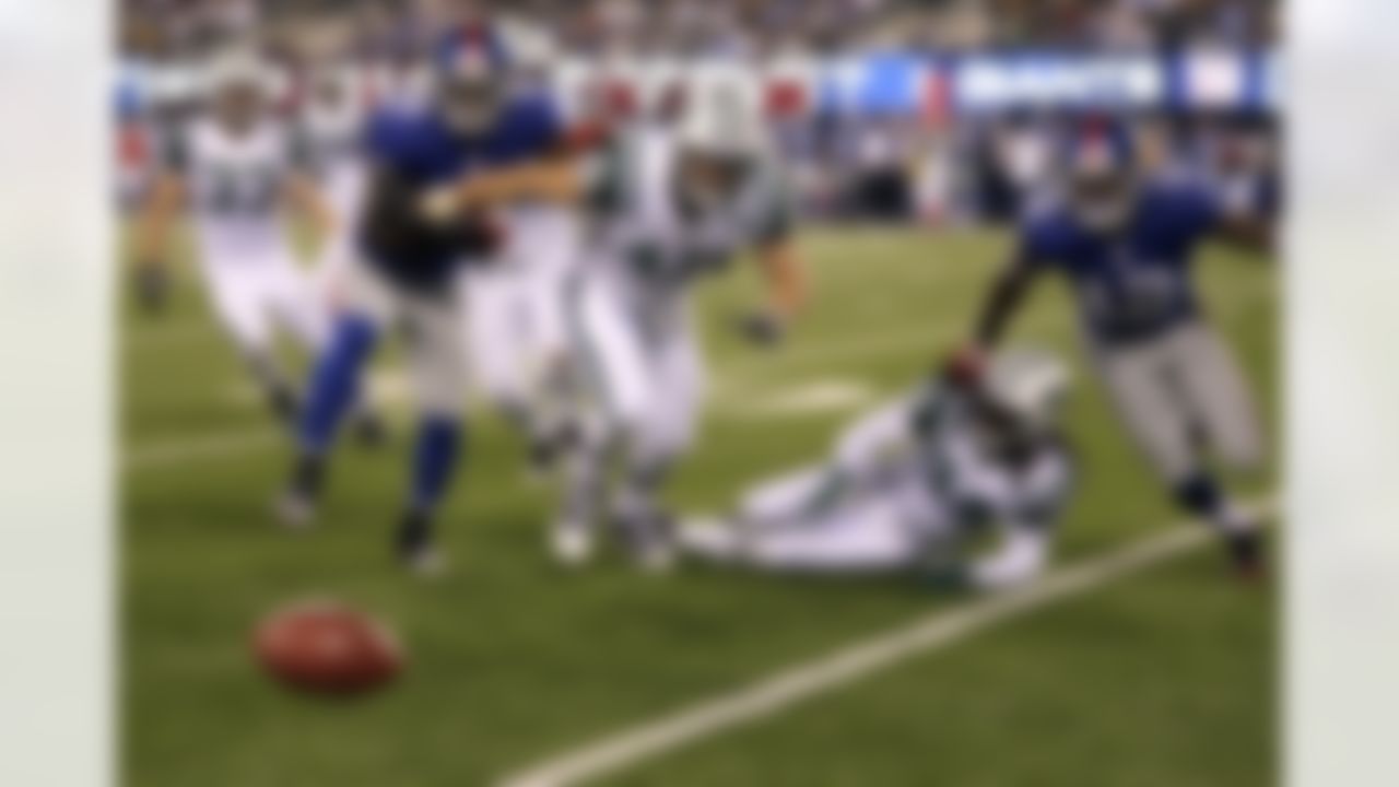 New York Giants and New York Jets chase a live ball after New York Giants' Jerrel Jernigan (12) failed to catch a punt during the third quarter of an NFL preseason football game Monday, Aug. 29, 2011, in East Rutherford, N.J. The ball went out of bounds, and the Giants took possession. (AP Photo/Julio Cortez)