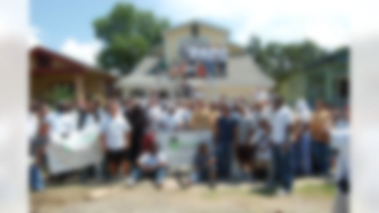 Members of the New Orleans Saints help to rebuild a home ravaged by Hurricane Katrina in New Orleans, Louisiana on June 10, 2008.