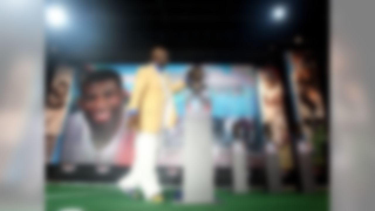 Deion Sanders puts a bandana on his bust at the 2011 Football Hall of Fame ceremony in Canton, Ohio on August 6, 2011 (AP Photo/Ben Liebenberg)