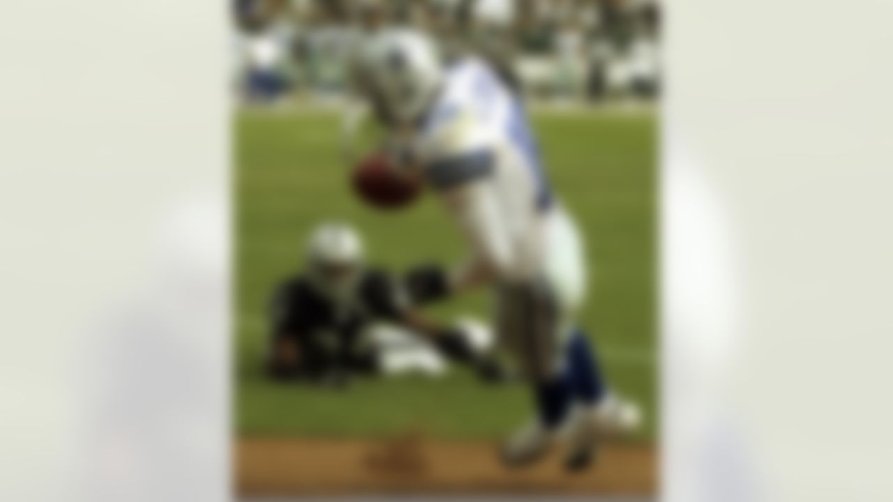 Dallas Cowboys' Keyshawn Johnson (19) falls into the end zone as Oakland Raiders' Charles Woodson watches in the third quarter on Sunday, Oct. 2, 2005, in Oakland, Calif. This touchdown was called back due to a Dallas penalty. The Raiders won their first game of the year, 19-13.