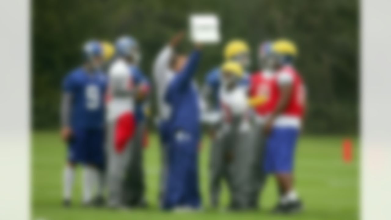 A New York Giants coach holds up a play sheet during a training session at the Chelsea soccer training ground, Cobham, Britain Friday Oct. 26, 2007. The New York Giants will face the Miami Dolphins at Wembley Sunday Oct. 28, 2007. (AP Photo/Tom Hevezi)