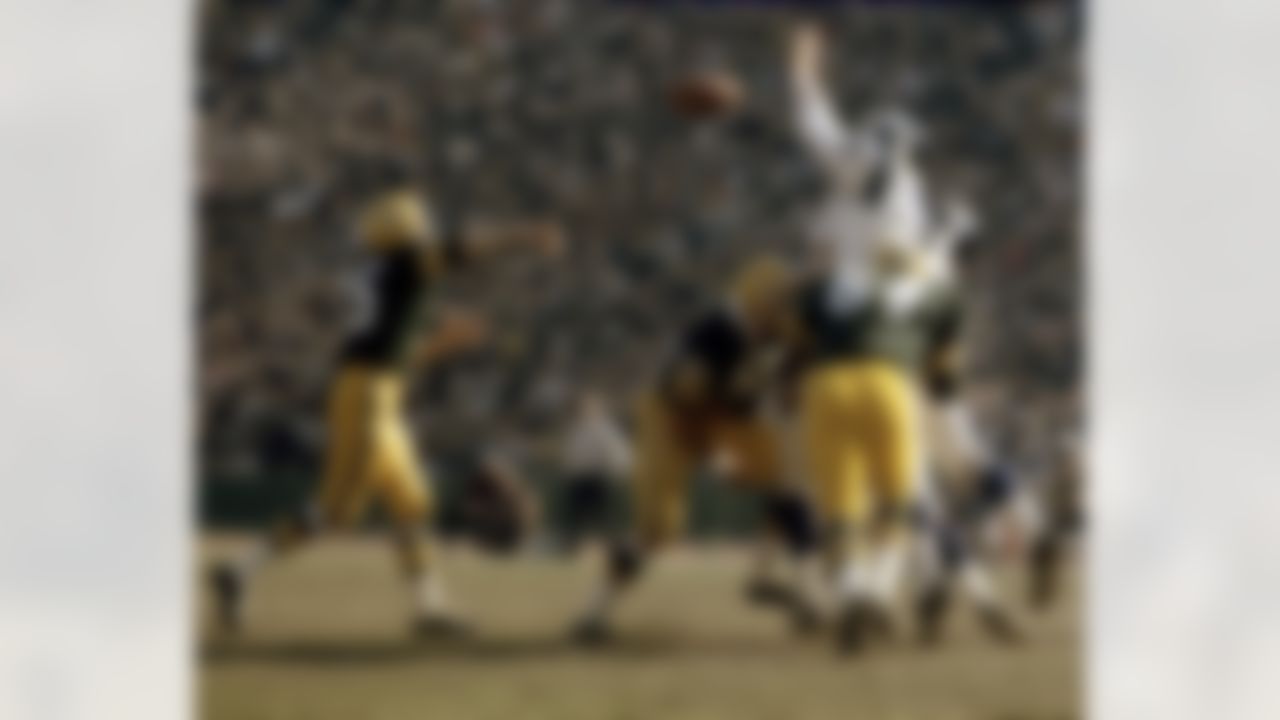 Green Bay Packers guard Jerry Kramer (64) blocks Los Angeles Rams Hall of Fame defensive tackle Merlin Olsen (74). but Olsen still manages to bat downGreen Bay Packers Hall of Fame quarterback Bart Starr's (15) pass during a 27-24 Rams victory. (AP Photo/NFL Photos)