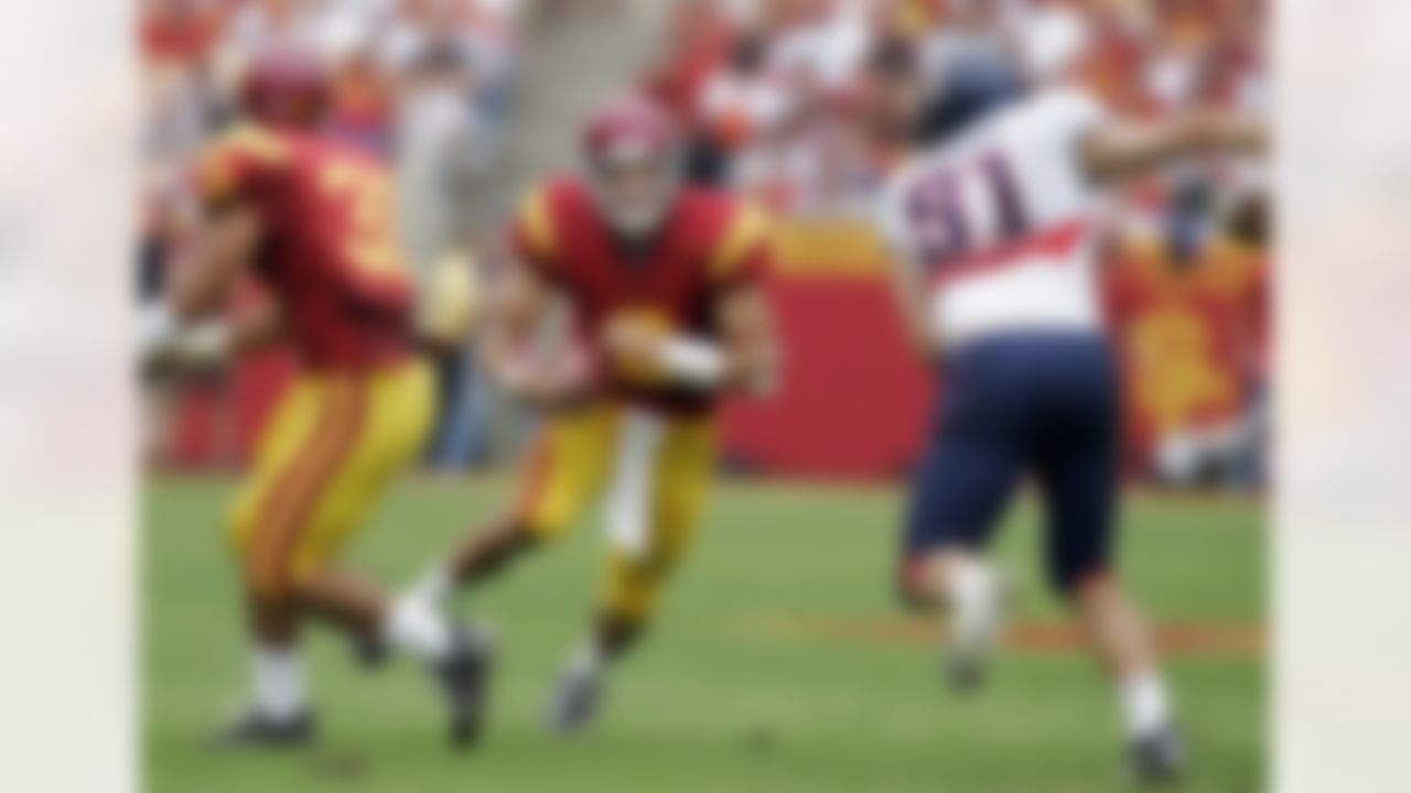 Southern California quarterback Mark Sanchez , center, runs the ball as Arizona linebacker Spencer Larsen (51) defends as USC's running back Stanley Havili, left, looks on during the first half of their NCAA Football game, Saturday, Oct. 13, 2007, in Los Angeles. USC won 20-13. (AP Photo/Mark J. Terrill)