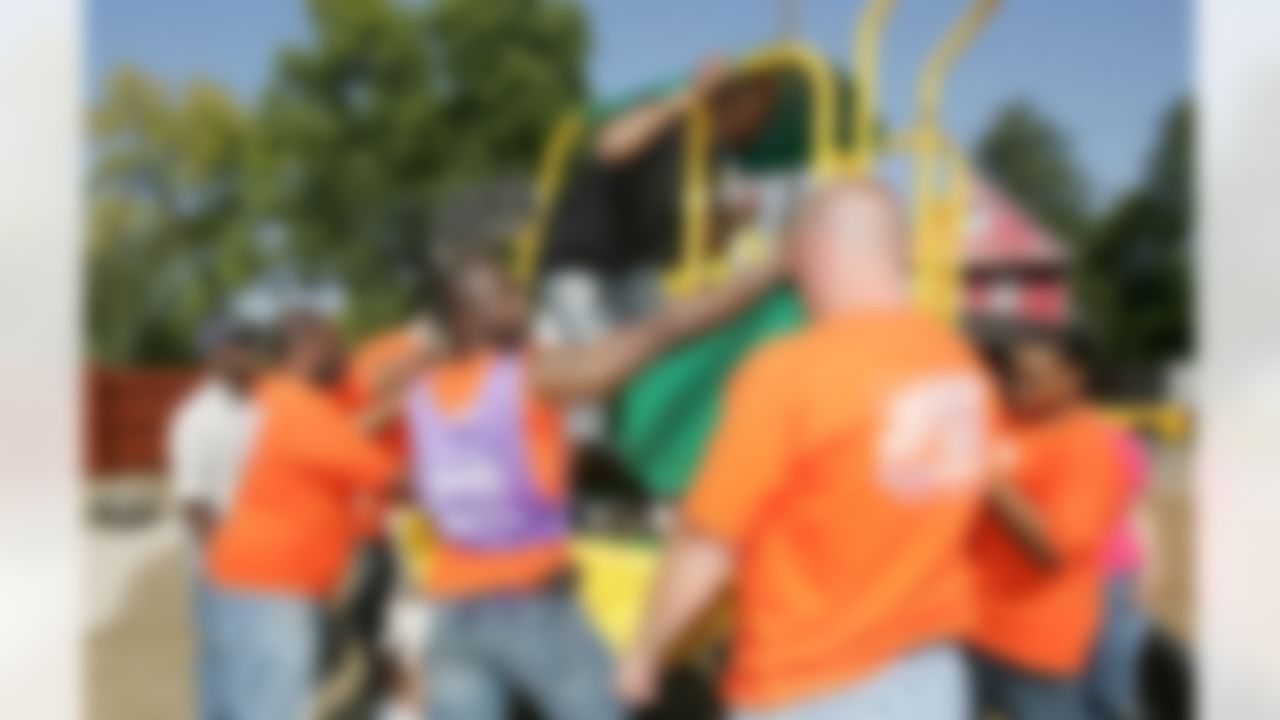 The Home Depot associates and KaBOOM! volunteers putting together one of the new playground pieces. (Photo by Alan Marler/CIA Stock Photography, Inc.)