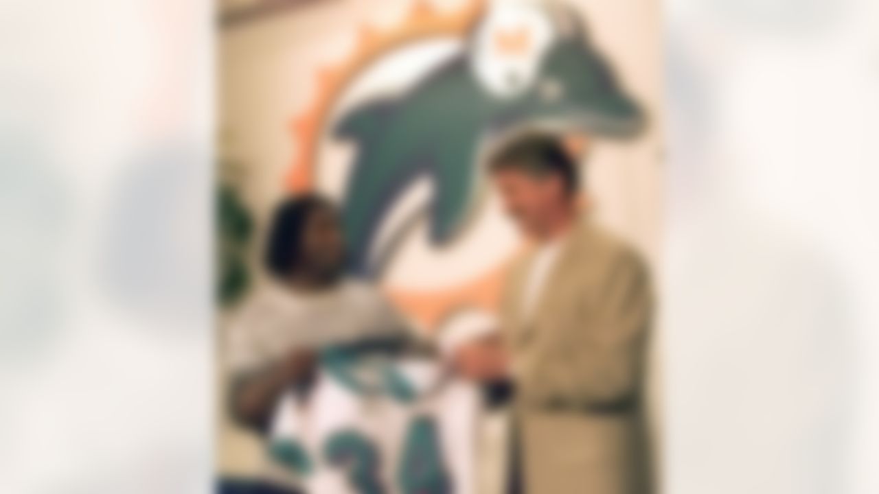 Miami Dolphins new running back Ricky Williams, left, and head coach Dave Wannstedt hold up Williams' new number 34 jersey during a new conference on Monday, March 11, 2002 at the Dolphins training facility in Davie, Fla. The New Orleans Saints traded Williams to Miami for a first-round pick in 2002 and a third-round pick in 2003 that could become a first-rounder depending on how Williams performs. (AP Photo/Wilfredo Lee)
