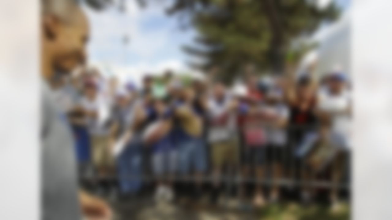 New York Giants wide receiver Victor Cruz, far left, is besieged by autograph-seeking fans after a practice at the New York Giants football training camp in Albany, N.Y., Friday, July 27, 2012. (AP Photo/Kathy Willens)