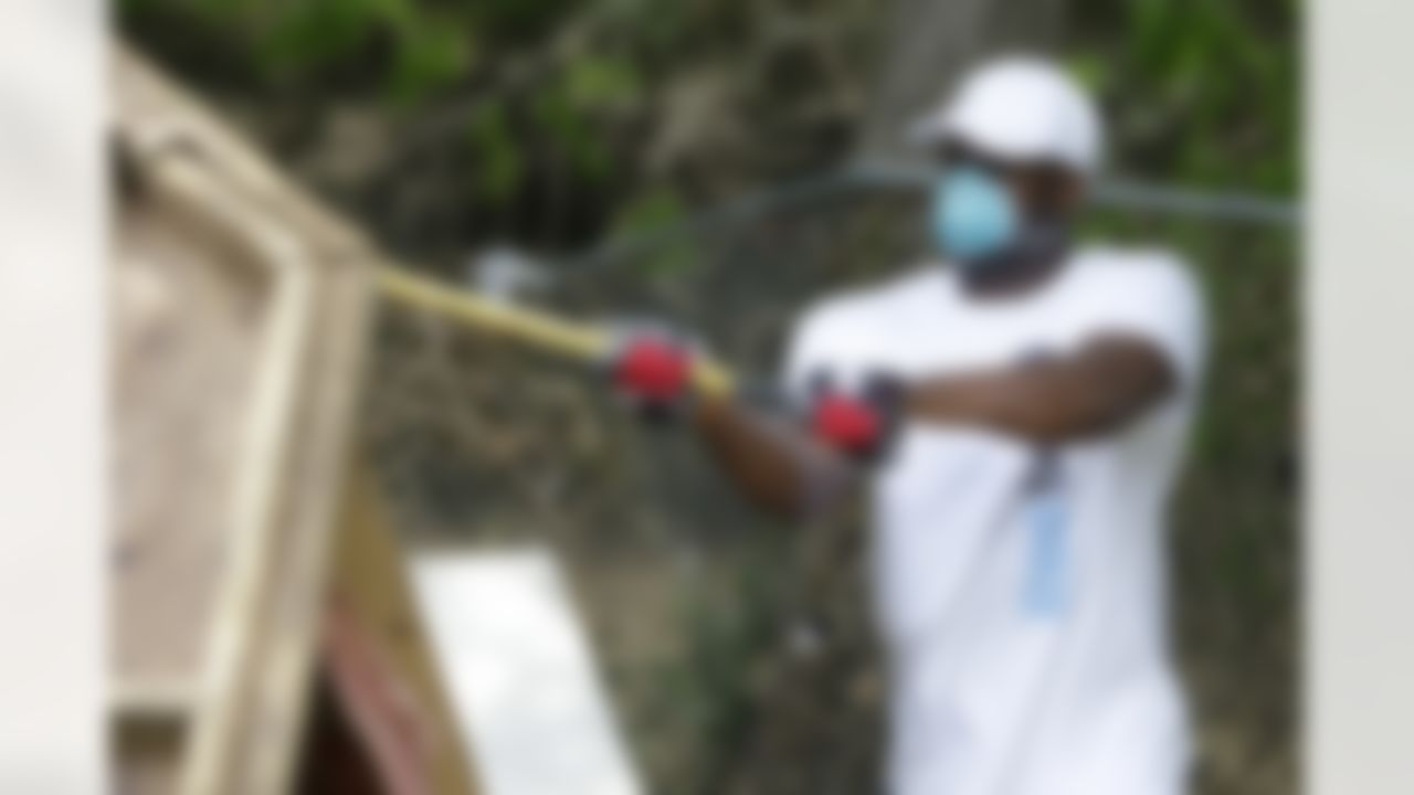Tennessee Titans quarterback Vince Young uses an ax to tear apart a utility building as Titans players, coaches and staff help to clean up homes damaged by floods on Wednesday, May 12, 2010, in Nashville, Tenn. (AP Photo/Mark Humphrey)