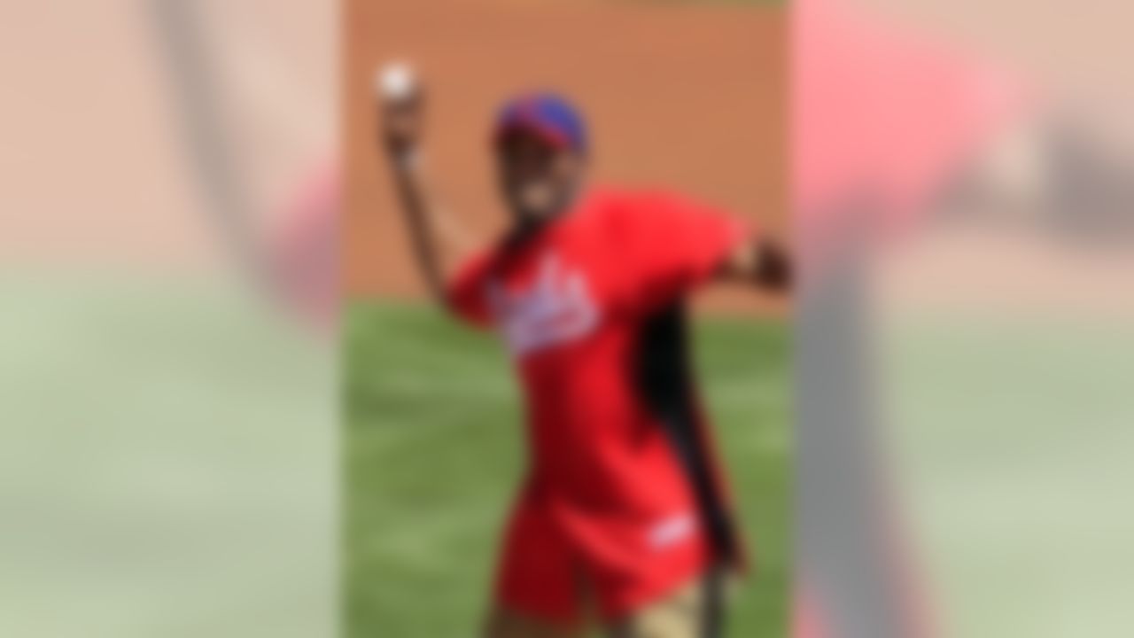 Arizona Cardinals and former Ohio State running back Beanie Wells throws out a ceremonial first pitch before a spring training baseball game between the Cleveland Indians and the Cincinnati Reds, Friday, March 30, 2012, in Goodyear, Ariz. (AP Photo/Mark Duncan)