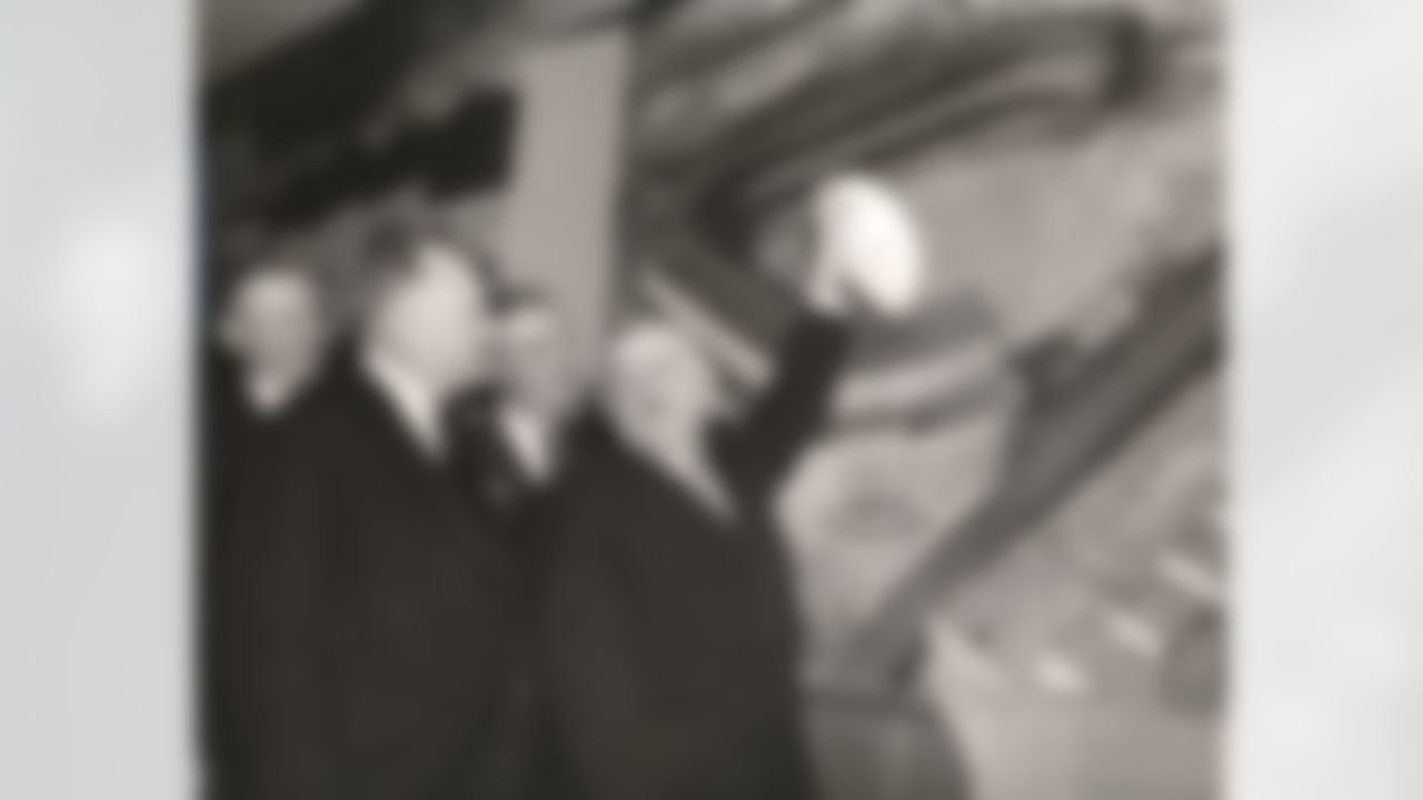 Wellington Mara, left rear, then New York Giants secretary and his brothers Jack Mara, right rear, Giants' president, pose with George Weiss, Yankees general manager, left front, and NFL Commissioner Bert Bell, near a mural of Yankee Stadium in New York, Jan. 27, 1956. Wellington Mara of the New York Giants, one of the NFL's most influential owners for more than a half century and the last of the league's founding generation, died Tuesday Oct. 25, 2005. He was 89. (Associated Press)