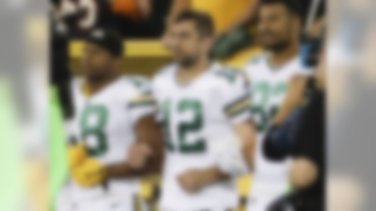 Green Bay Packers' Aaron Rodgers links arms with Richard Rodgers and Randall Cobb during the national anthem before an NFL football game against the Chicago Bears Thursday, Sept. 28, 2017, in Green Bay, Wis.