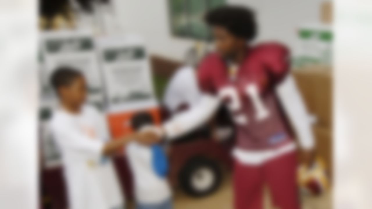 Washington Redskins safety Sean Taylor (21) meets with some children after practice at the NFL football team's training camp at Redskins Park in Ashburn, Va., on Aug. 2, 2007. (AP Photo/Nick Wass)