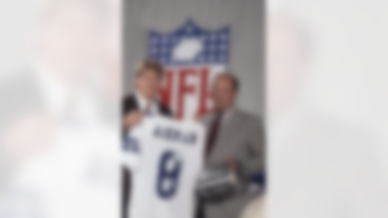 Pete Rozelle, NFL Commissioner, right, began the 54th annual draft of collegiate talent, his final draft, by announcing the selection of UCLA quarterback Troy Aikman, right, as the first pick by the Dallas Cowboys, Sunday, April 23, 1989 in New York. Aikman already has signed a six-year, $11.2 million contract with the Cowboys. (AP Photo/Mark Lennihan)