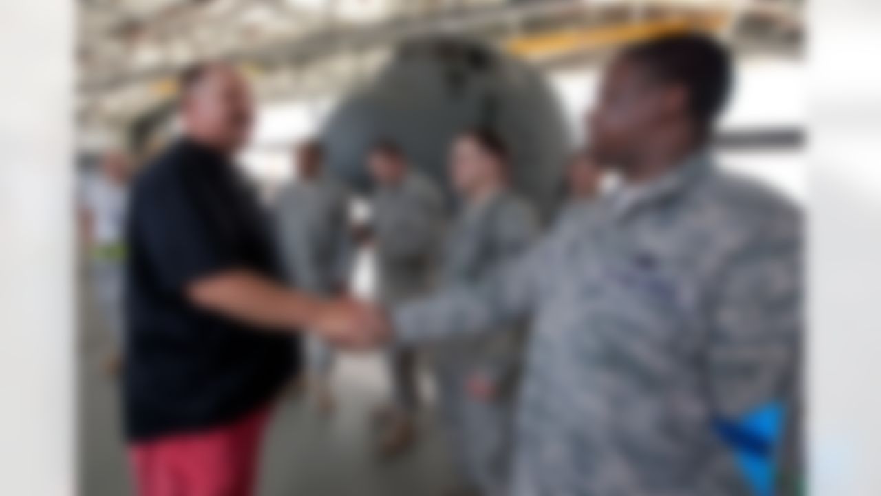 Philadelphia Eagles head coach Andy Reid visits with airmen who repair C-130 aircraft at Ramstein Air Base in Germany during a USO/Armed Forces Entertainment tour stop on June 30, 2010. This is Reid's first tour and he is joined by three other top NFL coaches who are touring bases in Germany and the Persian Gulf. (Fred Greaves/USO)
