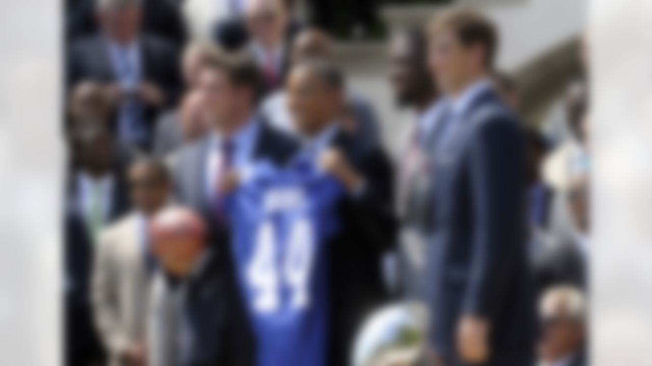 President Barack Obama poses with New York football Giants, including captains, from left, Zak DeOssie, Justin Tuck, and Eli Manning during a ceremony on the South Lawn of the White House in Washington, Friday, June 8, 2012, to honor the Super Bowl XLVI Champions. (AP Photo/Susan Walsh)