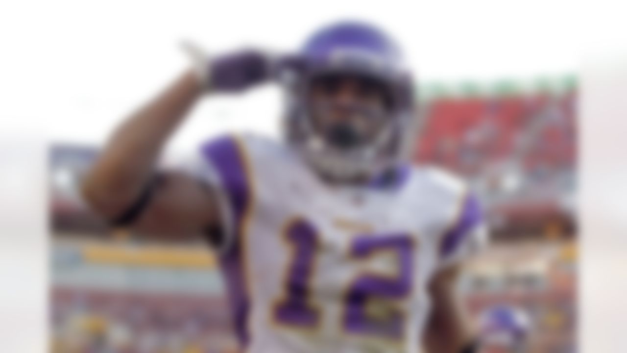 Minnesota Vikings wide receiver Percy Harvin (12) salutes the crowd after scoring a touchdown during the second half of an NFL football game against the Washington Redskins in Landover, Md., Saturday, Dec. 24, 2011. (AP Photo/Evan Vucci)