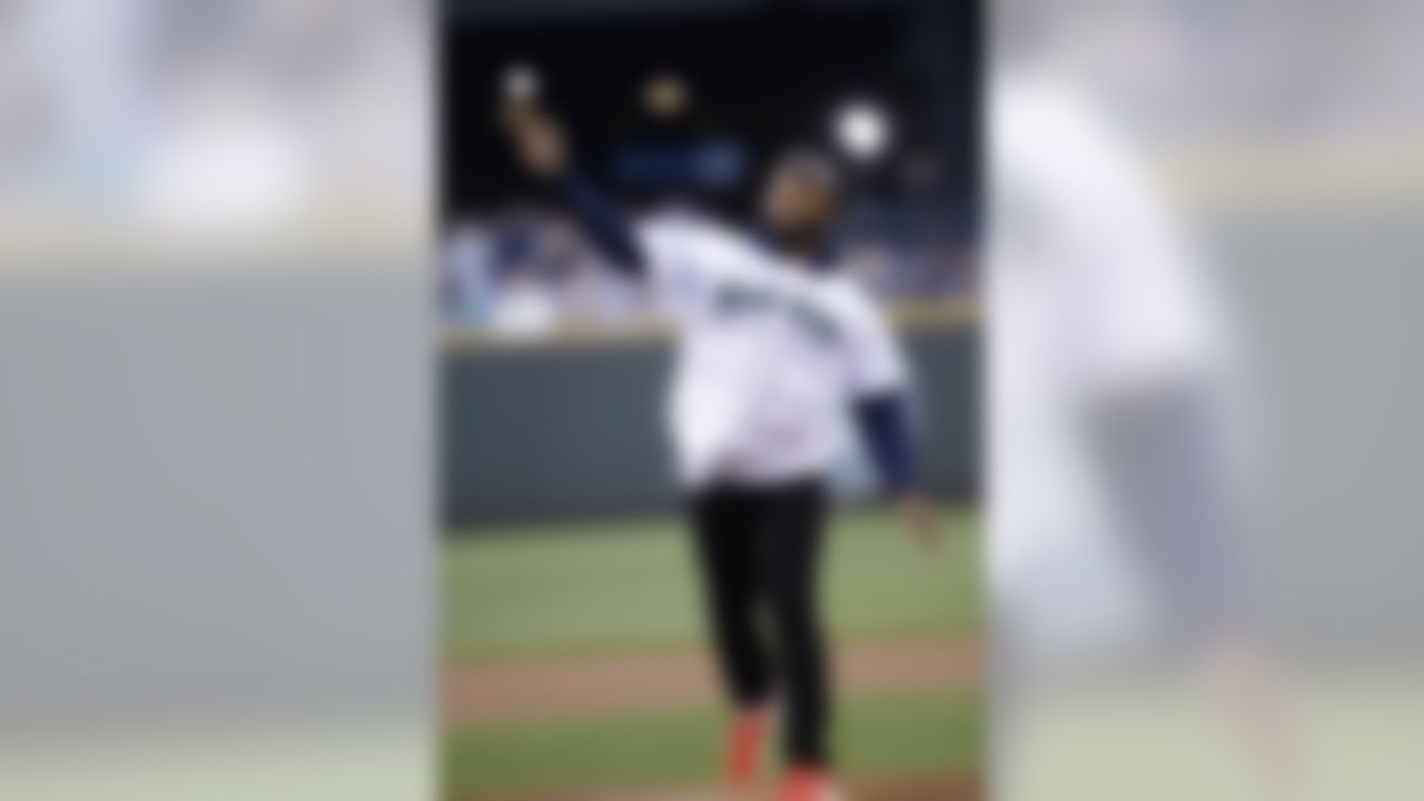 Seattle Seahawks' Michael Bennett throws out the ceremonial first pitch before a baseball game between the Seattle Mariners and Texas Rangers Friday, April 25, 2014, in Seattle. (AP Photo/Elaine Thompson)