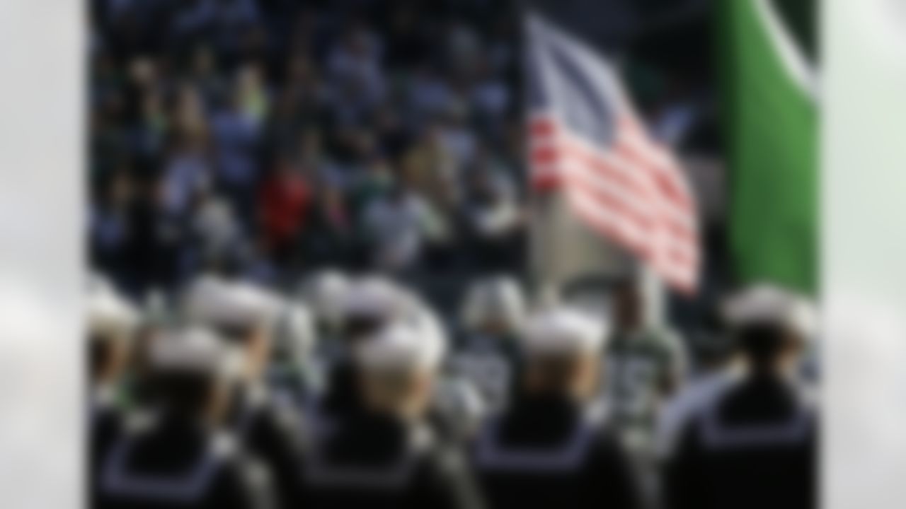 New York Jets wide receiver Brandon Marshall holds an American flag during Salute to Service ceremonies before the game against the Jacksonville Jaguars. (AP Photo/Seth Wenig)