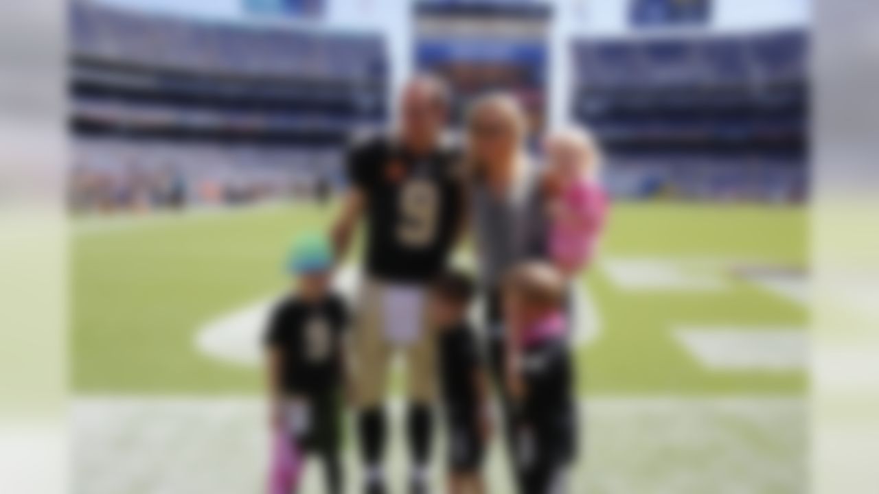 New Orleans Saints quarterback Drew Brees (9) and his family take a photo before an NFL football game against the San Diego Chargers, Sunday, Oct. 2, 2016, in San Diego. The Saints defeated the Chargers, 35-34. (Ryan Kang via AP)