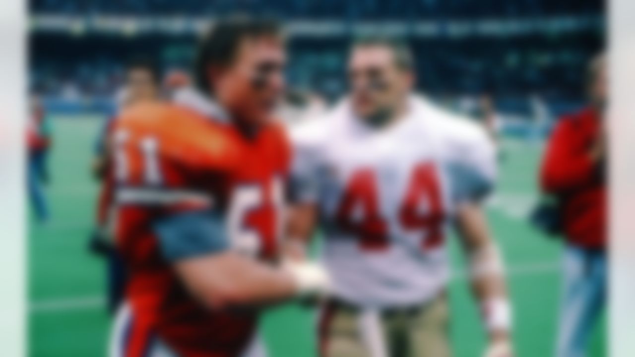 Denver Broncos linebacker Marc Munford (51) congratulates fellow Nebraska Cornhusker and San Francisco 49ers fullback Tom Rathman (44) after a Super Bowl XXIV NFL game against the San Francisco 49ers in New Orleans, on January 28, 1990. The 49ers defeated the Broncos 55-10. (AP Photo/Eric Lars Bakke)