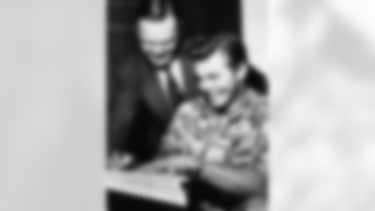 Kyle Rote, right, Southern Methodist University's great back, signs a one-year contract to play professional football with the New York Giants. Wellington Mara, secretary to the National Football League Club, watches the signing on March 8, 1951 at Dallas, Texas. Terms were not disclosed. Rote was the bonus draft choice of the Giants. (Associated Press)