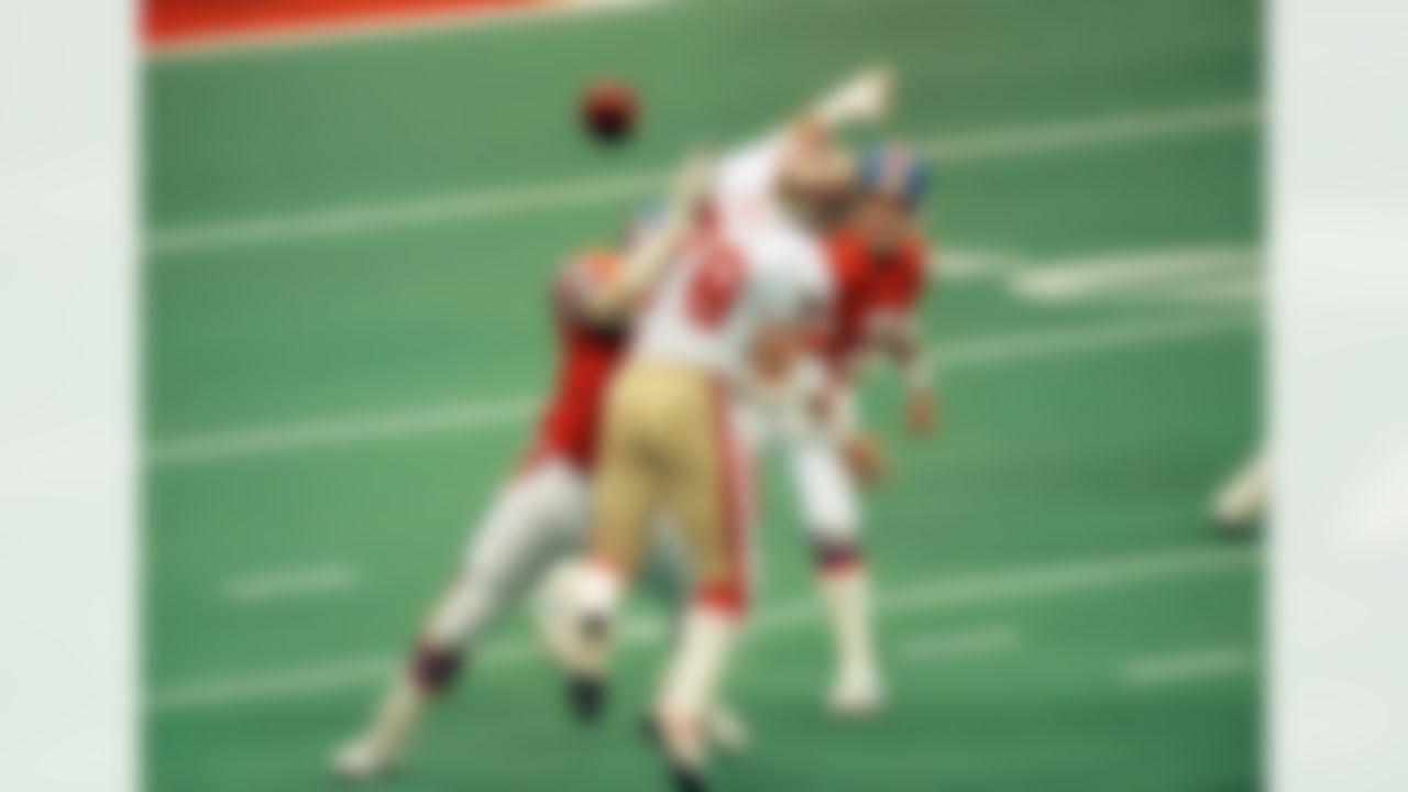 Denver Broncos quarterback John Elway, right, gets a pass off under pressure from San Francisco 49ers Pierce Holt (78) in the first quarter, Sunday, Jan. 28. 1990 in New Orleans Super Bowl XXIV. (AP Photo/Doug Pizac)