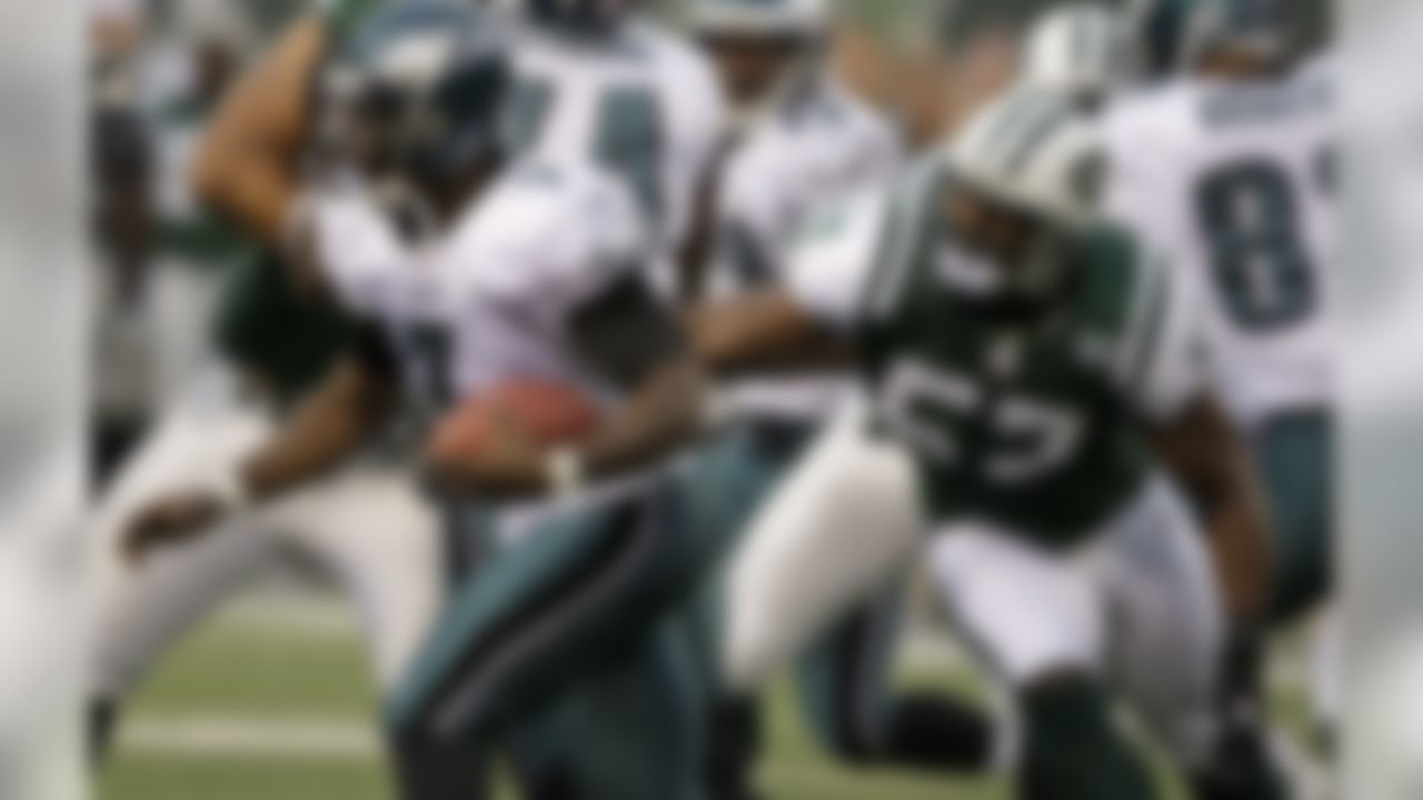 Philadelphia Eagles' Michael Vick (7) evades New York Jets linebacker Bart Scott (57) during the first quarter of an NFL preseason football game at Giants Stadium, Thursday, Sept. 3, 2009, in East Rutherford, N.J. (AP Photo/Peter Morgan)
