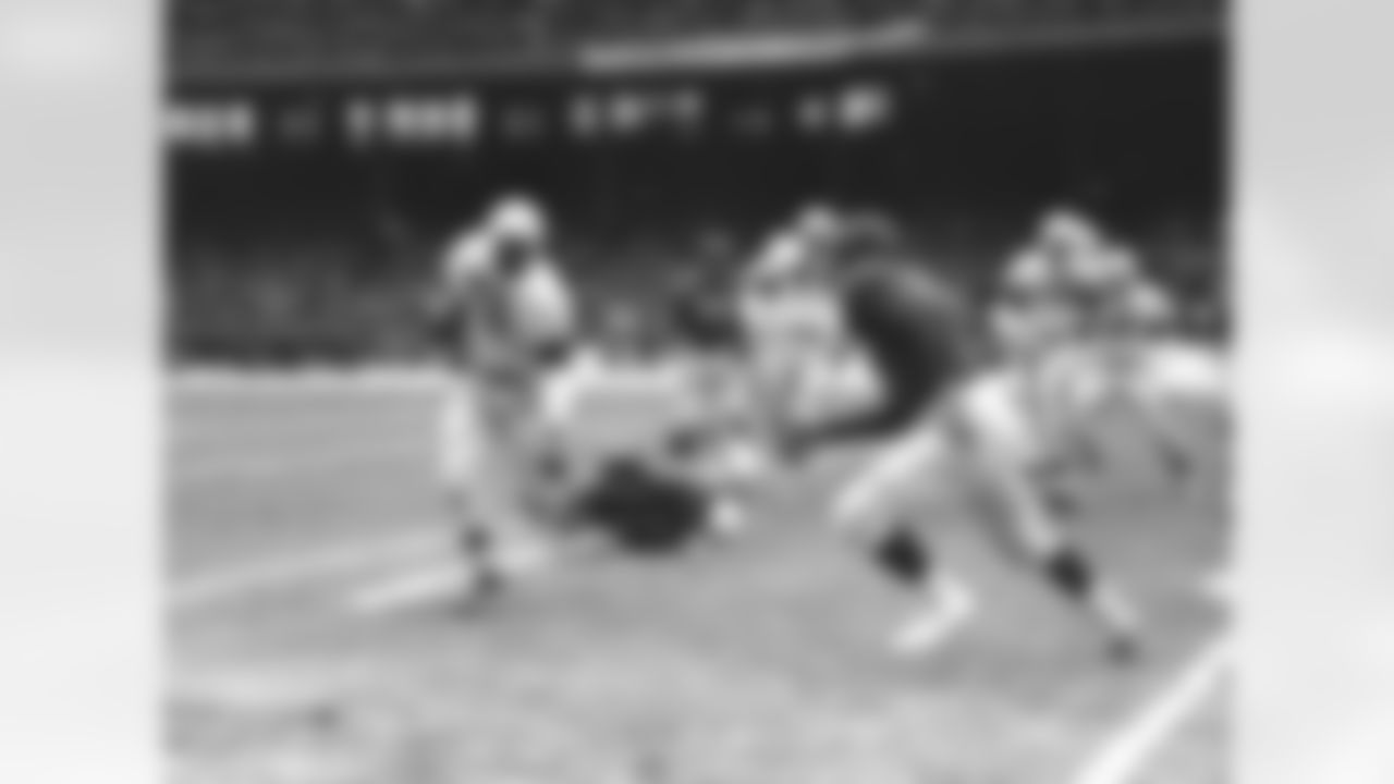 Cleveland Browns Fullback Marion Motley (76) gains one yard before he is pulled down by New York Giants� Jim Duncan, right, in the first period of the playoff game in Cleveland, Ohio, on Dec. 17, 1950. Motley has just eluded Arnie Weinmeister (73), Giants tackle, lying on the ground in the center. (AP Photo/Harold Valentine)