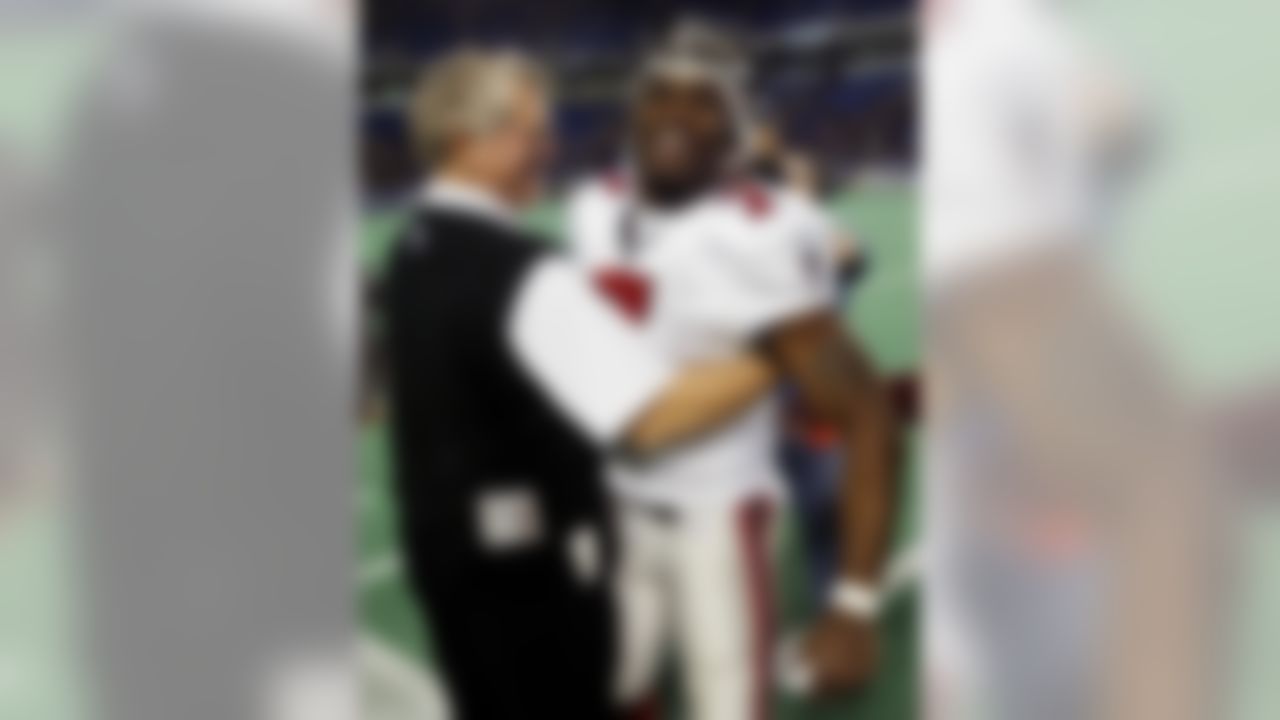 Atlanta Falcons, quarterback Michael Vick (7) is congratulated by head coach Dan Reeves, left, as he leaves the field after he scored the winning touchdown in overtime against the Minnesota Vikings, Sunday Dec. 1, 2002, in Minneapolis. The Falcons won 30-24. (AP Photo/Paul Battaglia)