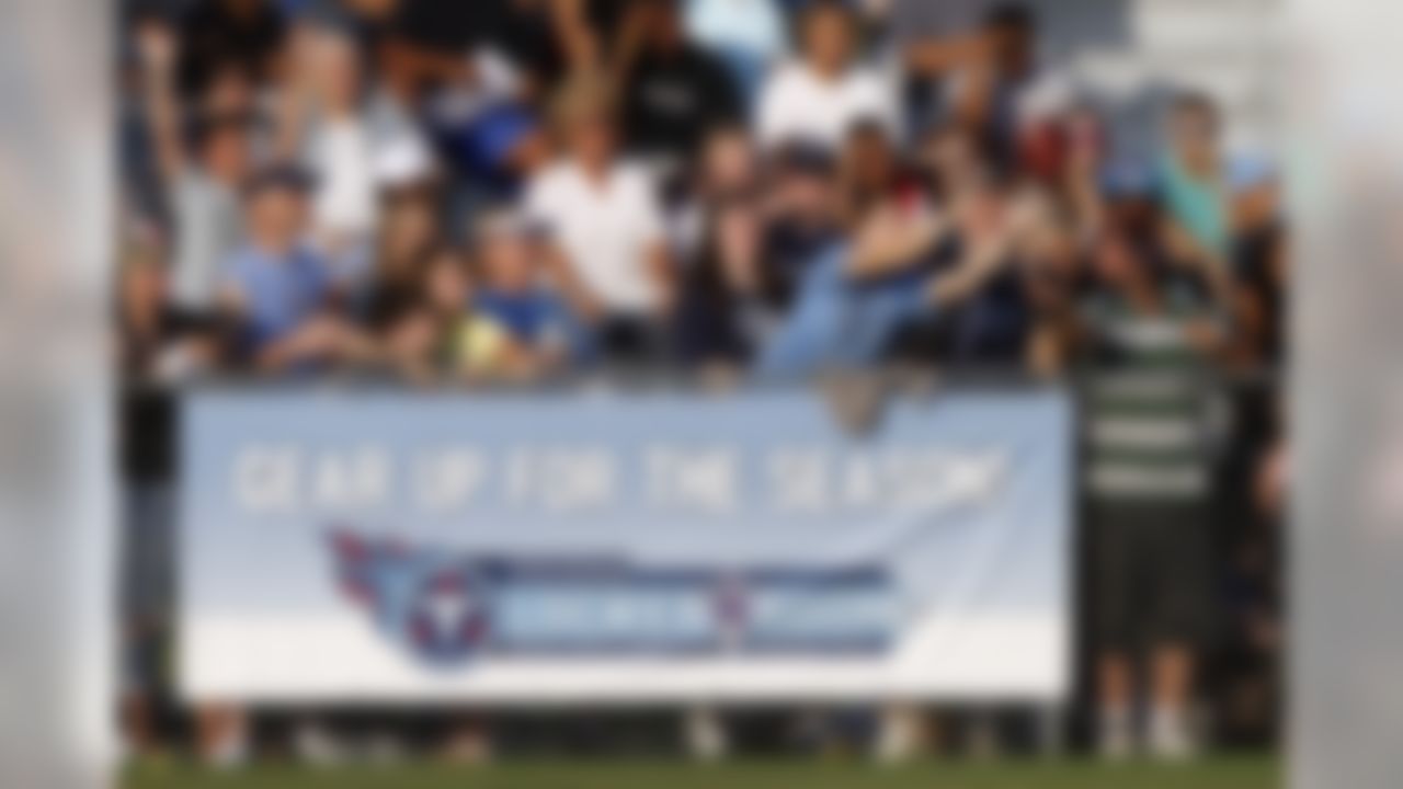 A fan makes a catch after a player threw the ball into the crowd during NFL football camp at Titans' headquarters Sunday, July 29, 2012 Nashville, Tenn. (AP Photo/Wade Payne)