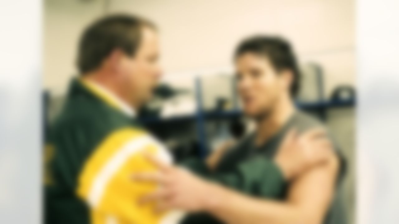 Green Bay Packers head coach Mike Holmgren congratulates quarterback Brett Favre (4) following the NFL Wildcard Playoff, a 28-24 victory over the Detroit Lions on January 8, 1994, at the Pontiac Silverdome in Pontiac, Michigan. Favre threw the game-winning touchdown pass with less than a minute left in the game. (AP Photo/Vernon Biever)