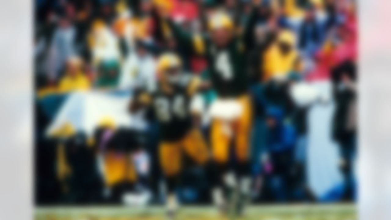 Green Bay Packers quarterback Brett Favre (4) celebrates a four-yard touchdown pass to wide receiver Andre Rison (84) during the NFC Divisional Playoff, a 35-14 victory over the San Francisco 49ers on January 4, 1997, at Lambeau Field in Green Bay, Wisconsin. (AP Photo/Vernon Biever)