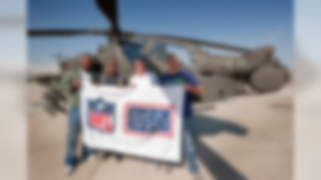 Houston Texans' Mario Williams(L), San Francisco 49ers' Vernon Davis (L-middle), Dallas Cowboys' Jason Witten (R-middle) and Cleveland Browns' Joe Thomas (R) pose for a photo in front of an Apache AH-64D helicopter (of the Warlords), March 5, 2010.  The four NFL All-Stars are participating in their first-ever USO tour, traveling to nine bases in eight days to visit troops serving in the Persian Gulf. (USO Photo by Dave Gatley.)