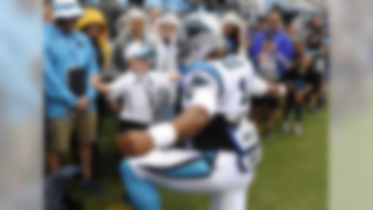 Carolina Panthers quarterback Cam Newton check bumps a young fan before taking on the New Orleans Saints. (AP Photo/Mike McCarn)