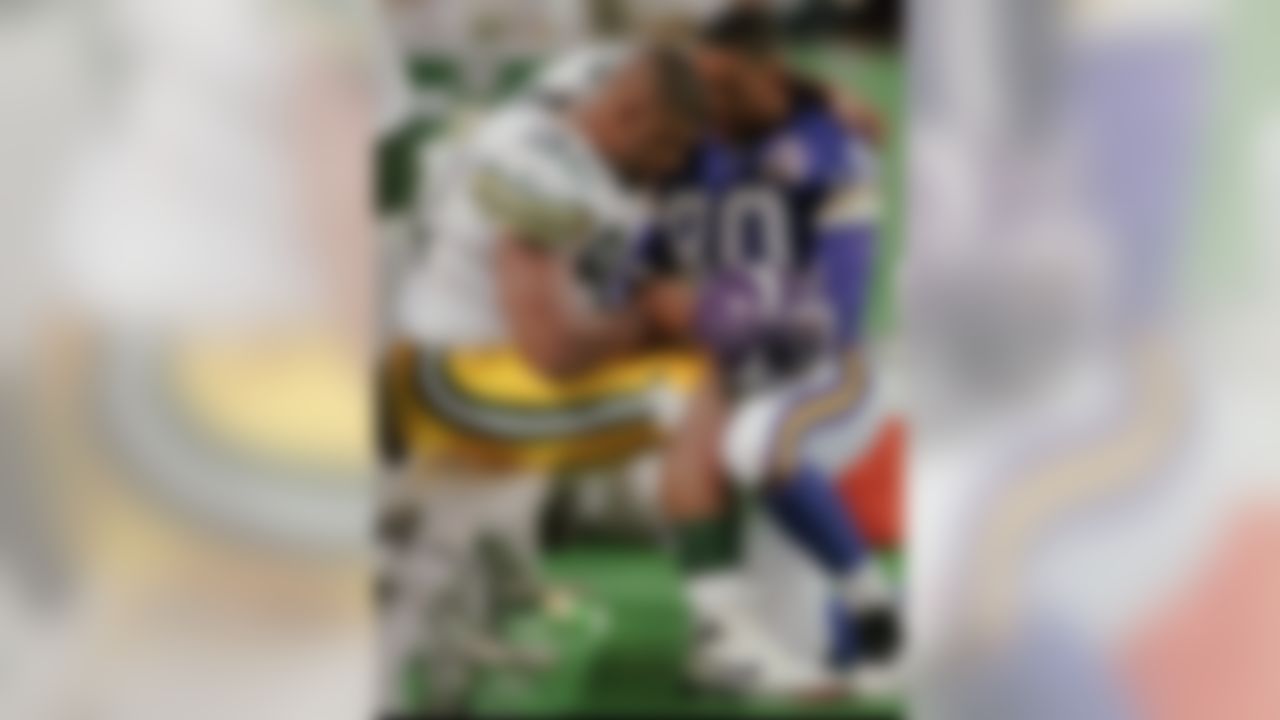 Minnesota Vikings wide receiver Cris Carter, right, and Green Bay Packers defensive end Reggie White share a moment in prayer at the Packers bench after their game in which White suffered a fourth quarter sprained knee and had to leave the game Sunday, Nov. 5, 1995, in Minneapolis. The Vikings won 27-24 on a last-second field goal. (AP Photo/Jim Mone)