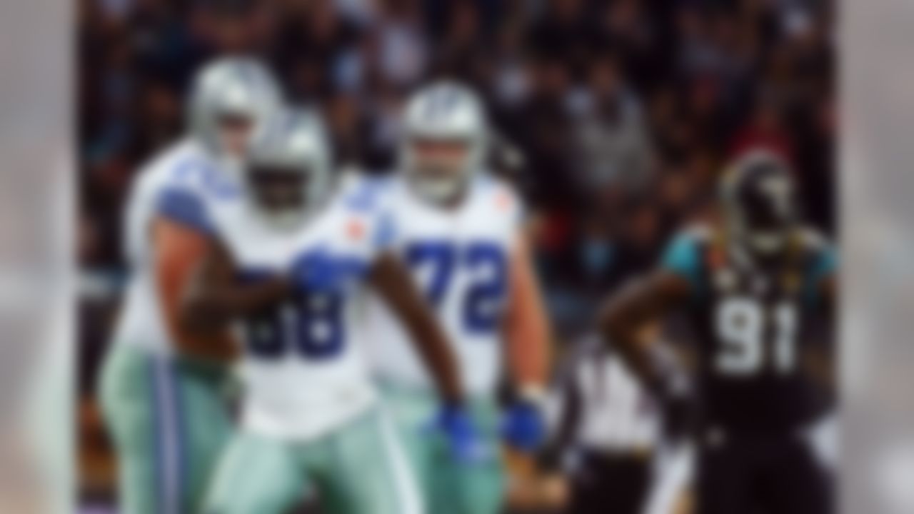 Dallas Cowboys wide receiver Dez Bryant (88) celebrates his touchdown against the Jacksonville Jaguars with guard Zack Martin (70) and center Travis Frederick (72) as defensive end Chris Clemons (91) looks on during the first half of an NFL football game at Wembley Stadium, London, Sunday, Nov. 9, 2014. (AP Photo/Tim Ireland)